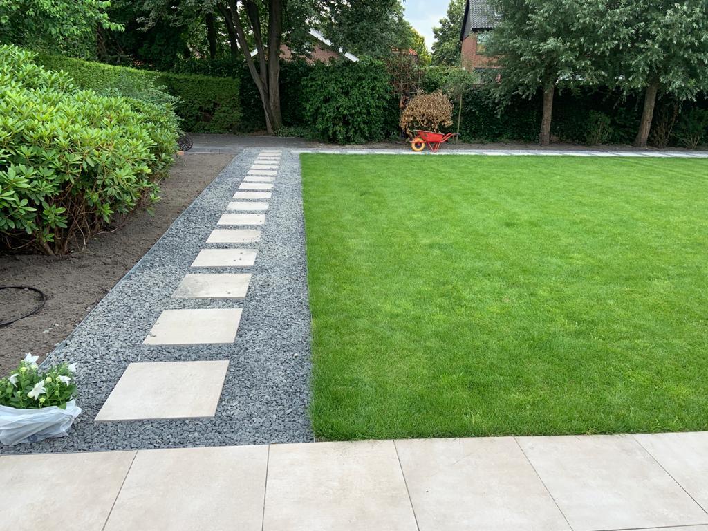 Foto-met-gemaaid-gras-en-gelegde-terrastegels-met-kiezels-voor-een-nettere-tuin